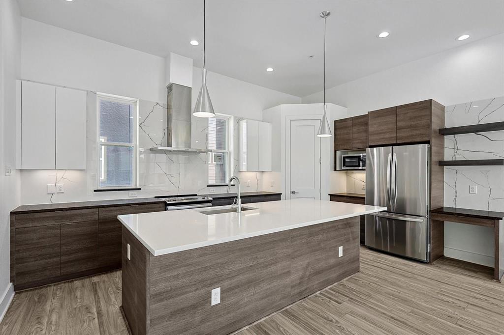 a kitchen with stainless steel appliances granite countertop a sink refrigerator and cabinets