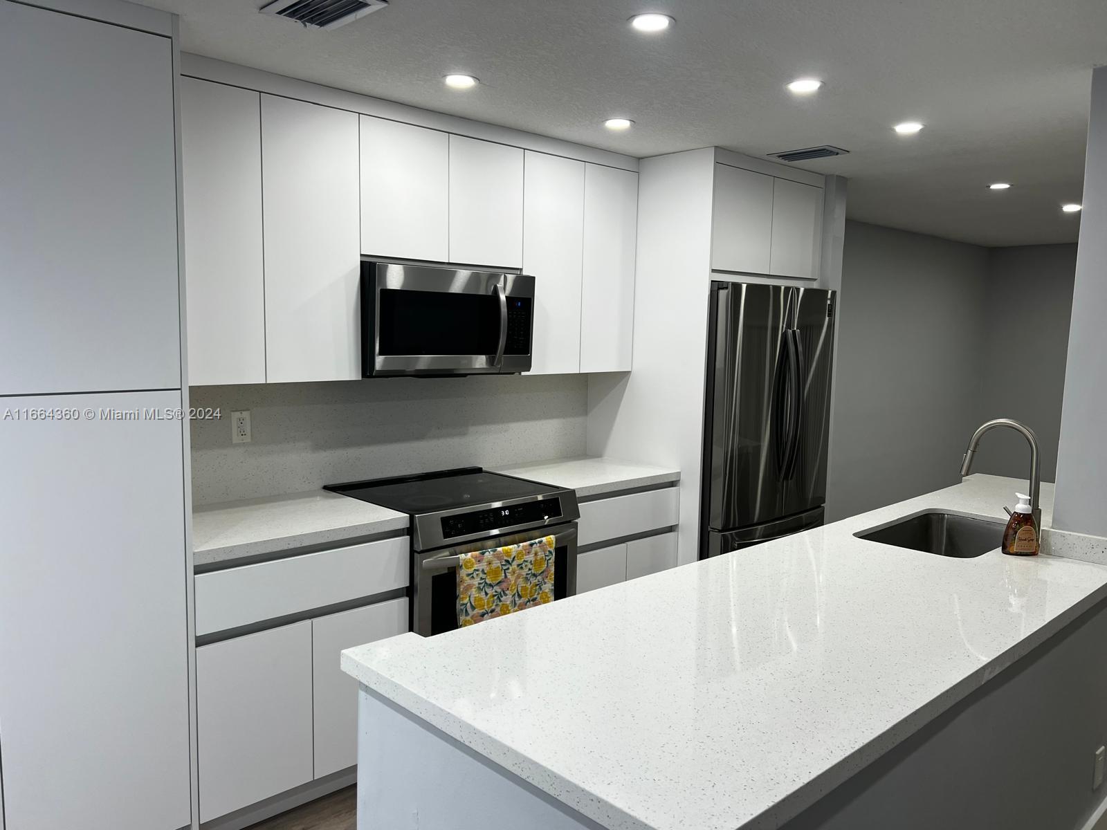 a kitchen with a refrigerator and a stove top oven