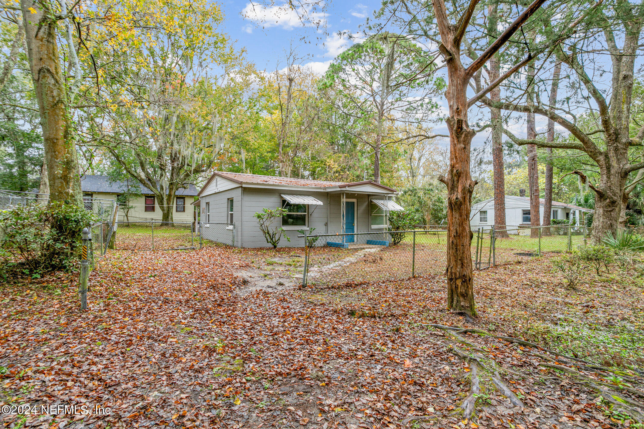 a view of house with a backyard and trees