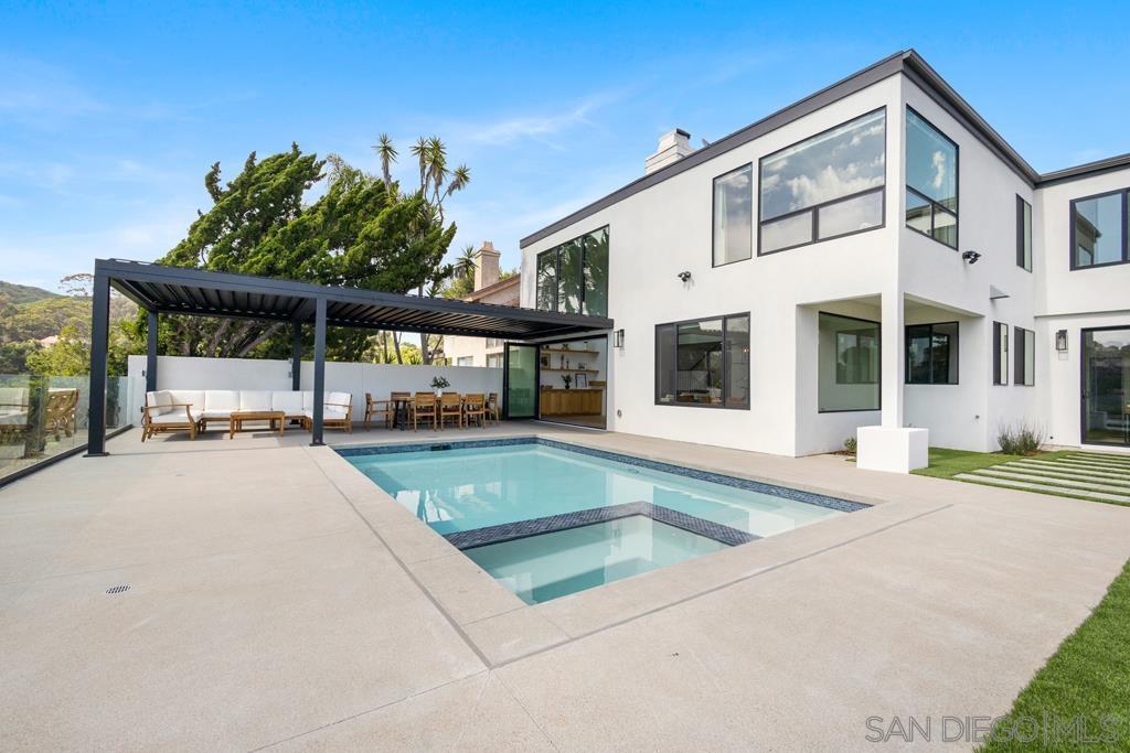 a view of a house with backyard and sitting area