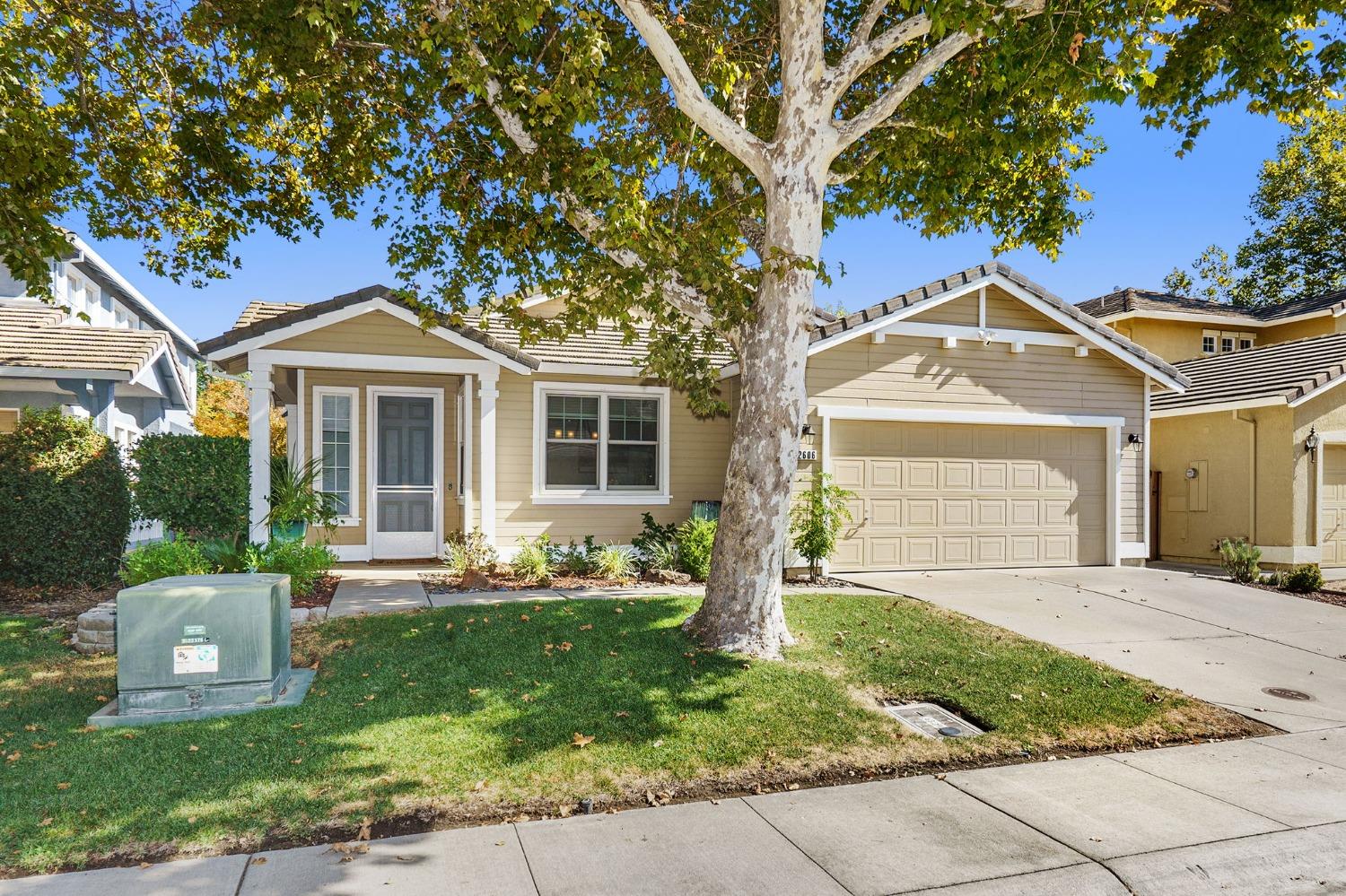 a front view of a house with a yard and trees