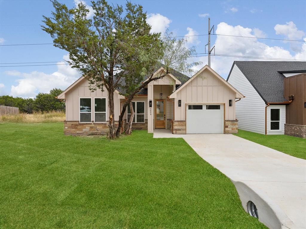 a front view of a house with a garden and yard