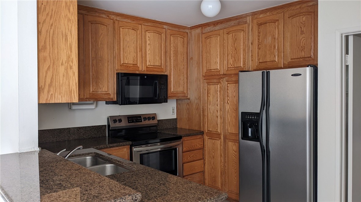 a kitchen with stainless steel appliances granite countertop a refrigerator stove and sink