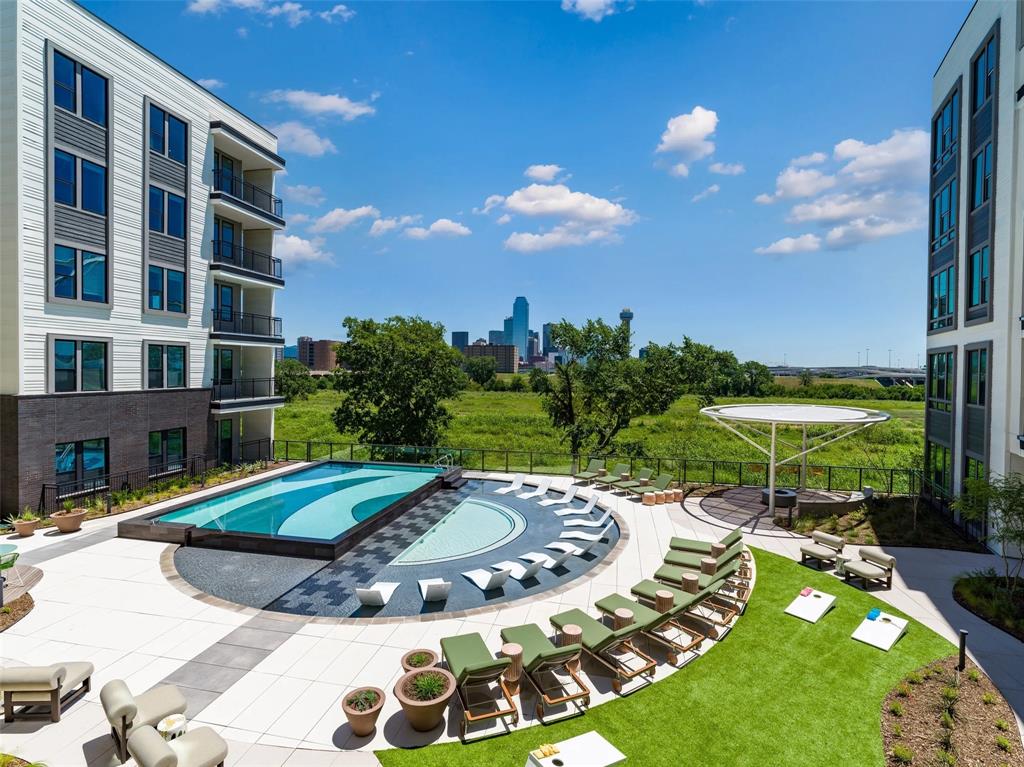 a view of a swimming pool with a patio and a yard