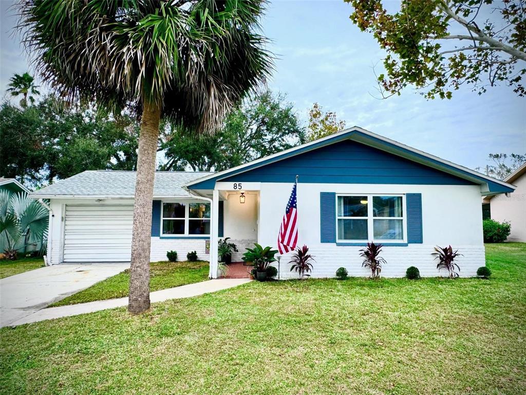 a front view of house with yard and outdoor seating