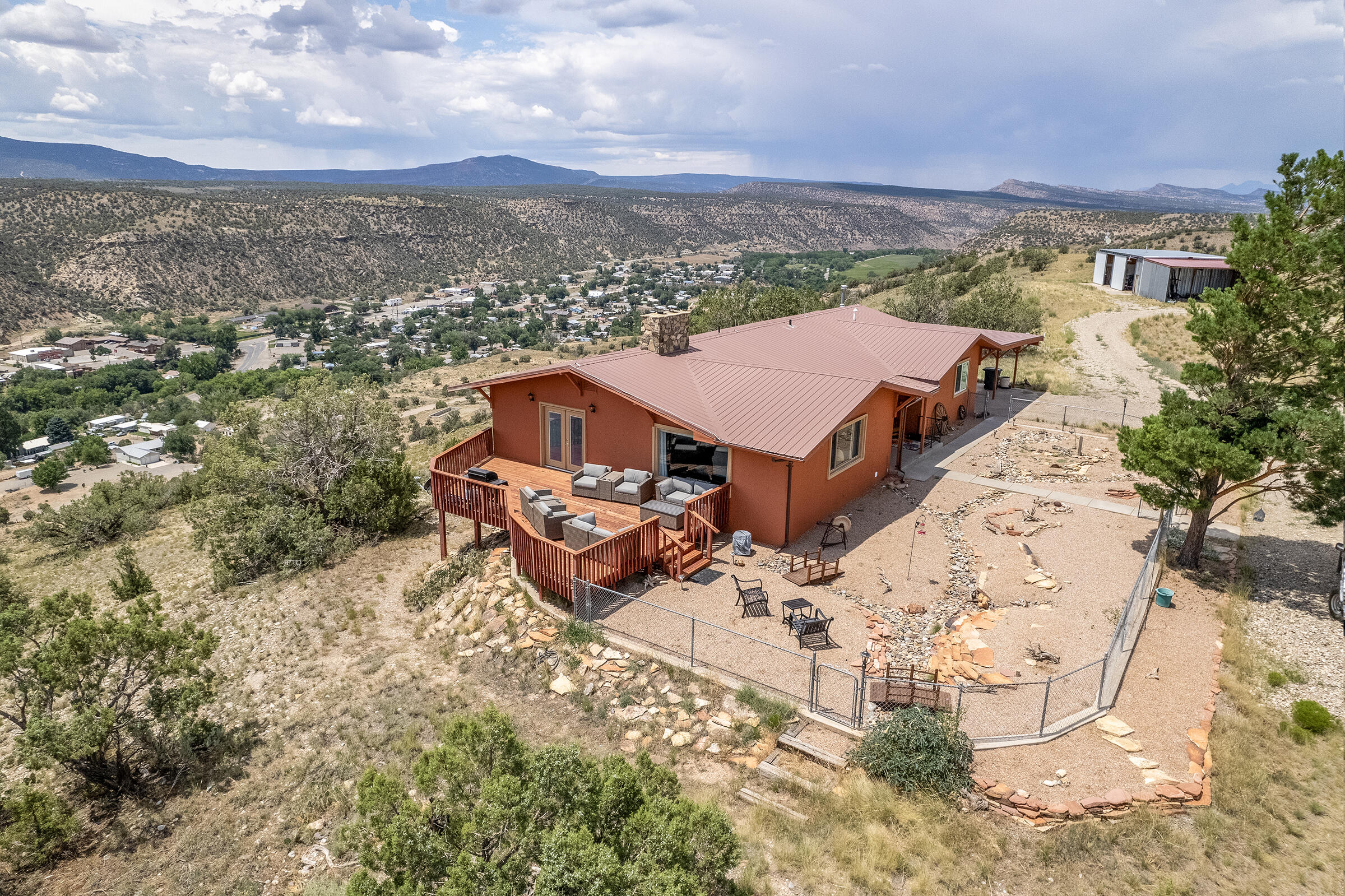 an aerial view of a house with a yard and mountain view in back