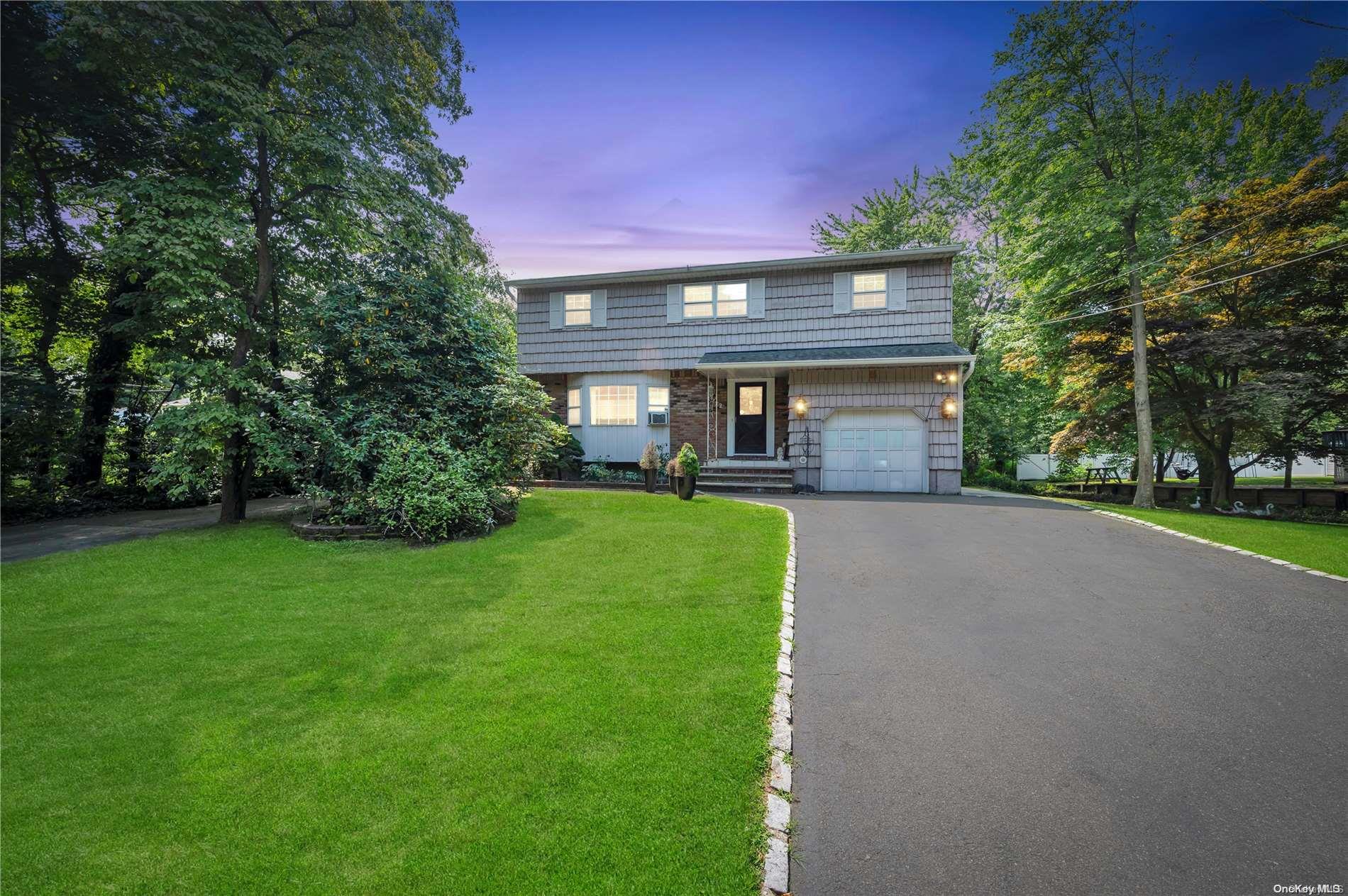 a front view of a house with a yard and trees