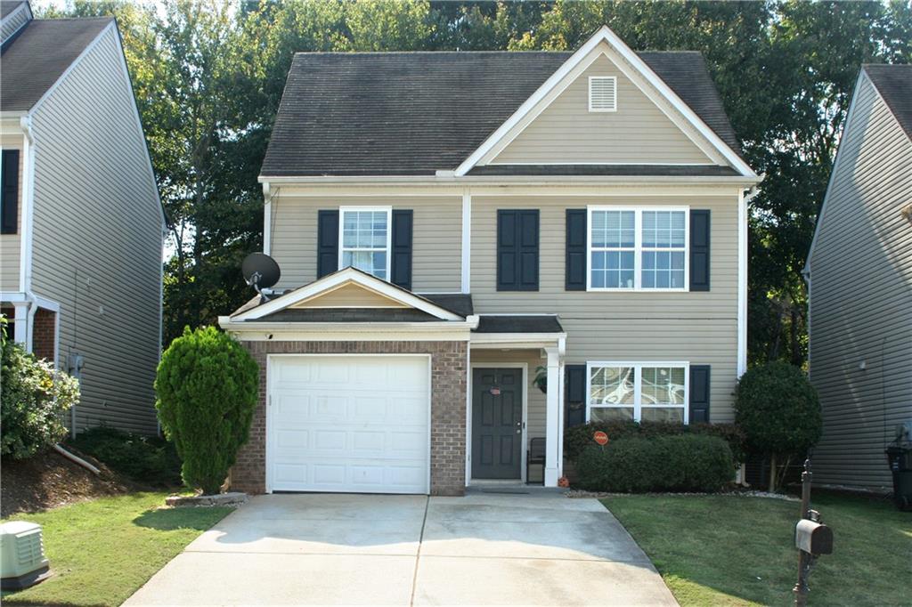 a front view of a house with a yard and garage