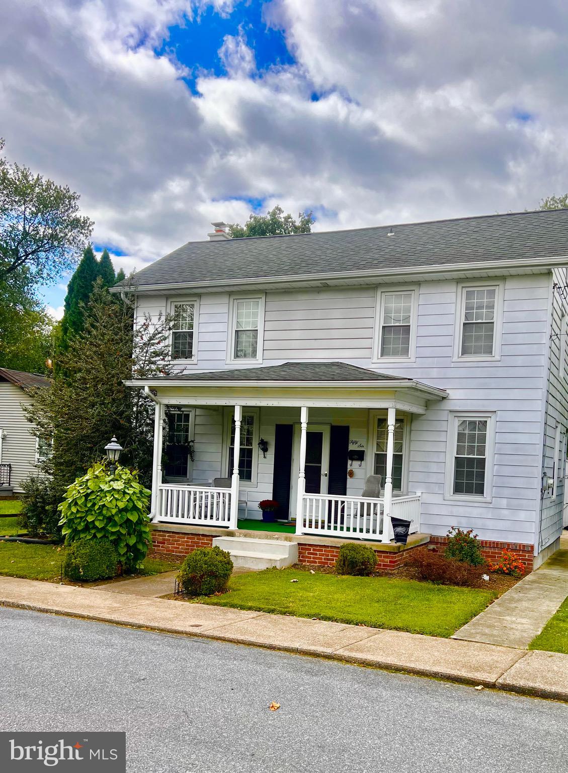 front view of house with a yard and plants