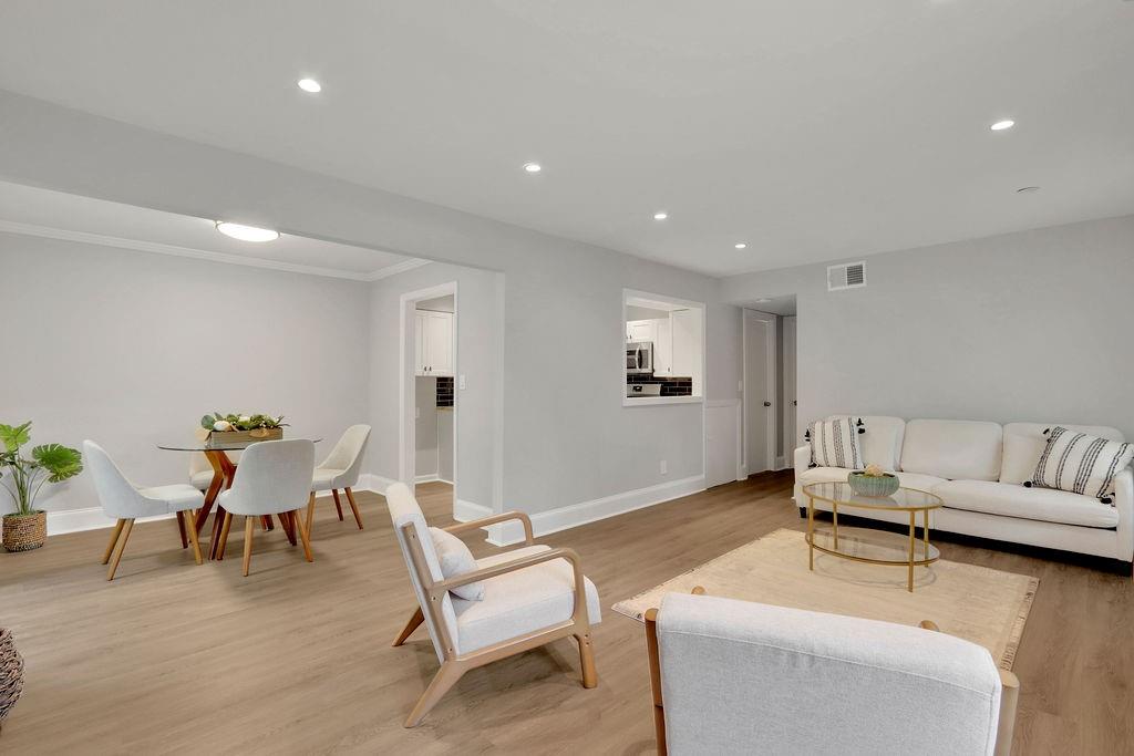 a living room with furniture and a wooden floor