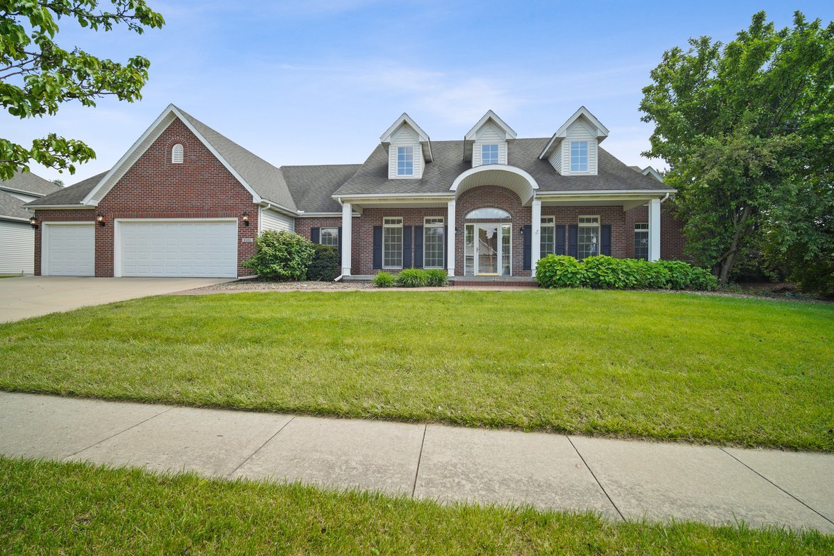 a front view of a house with a garden and trees