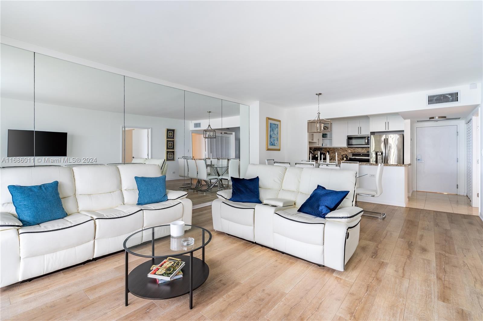 a living room with furniture and kitchen view