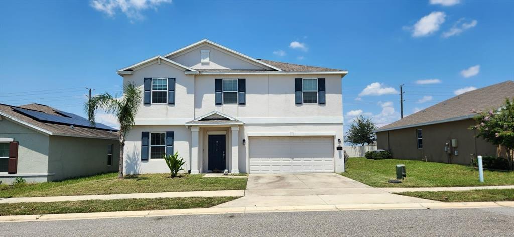 a front view of a house with a yard and garage