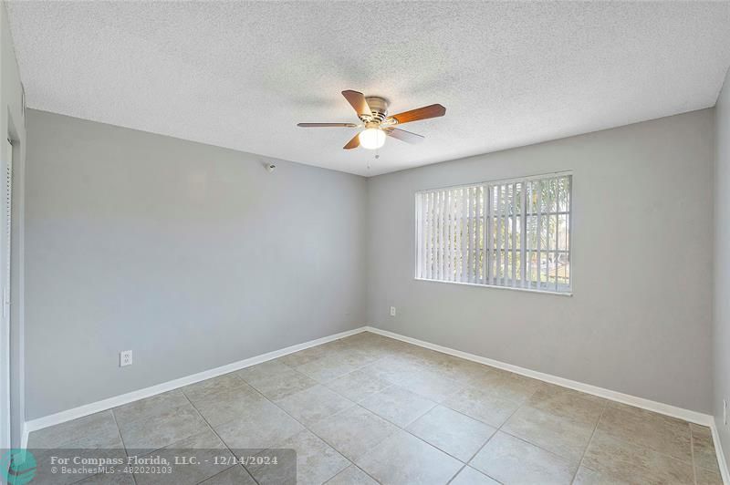 a view of a room with a ceiling fan and a window