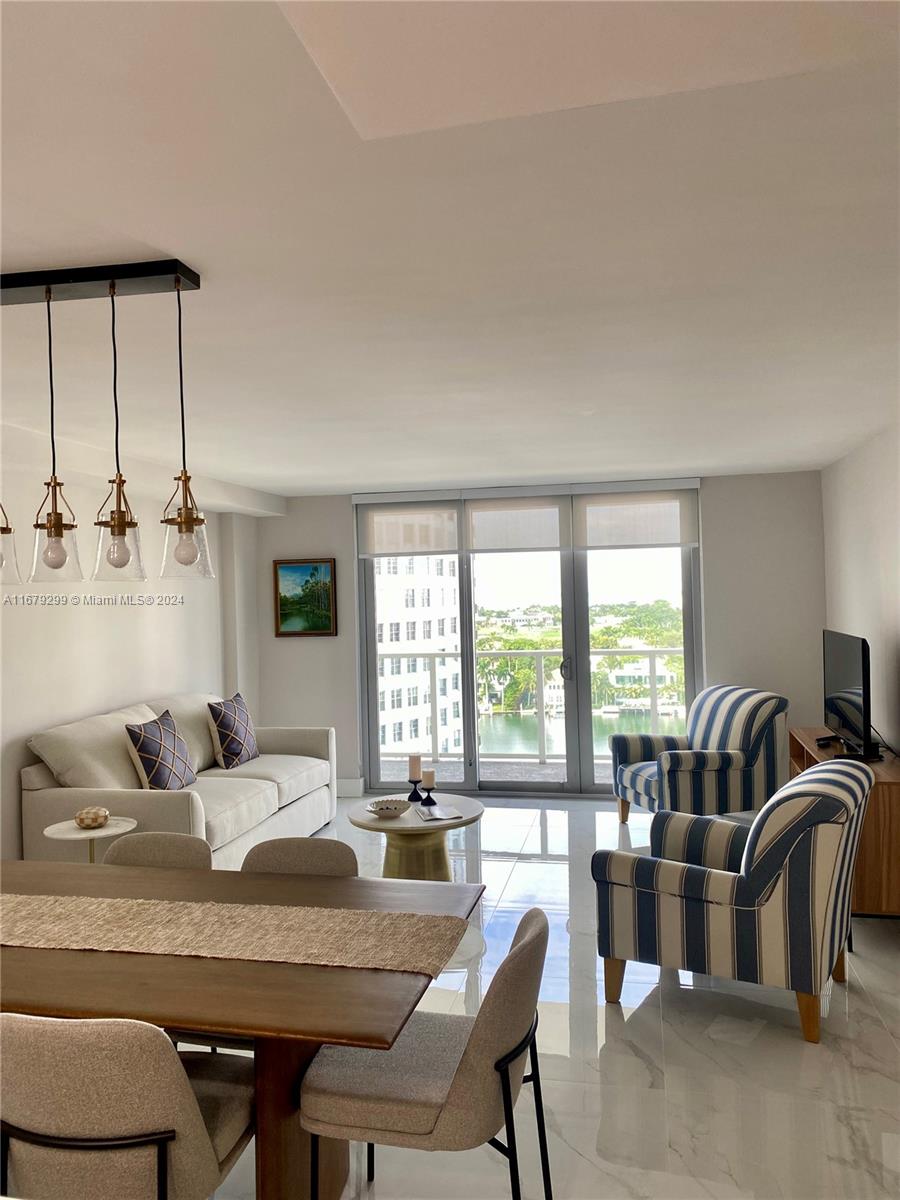 a living room with furniture and two large window