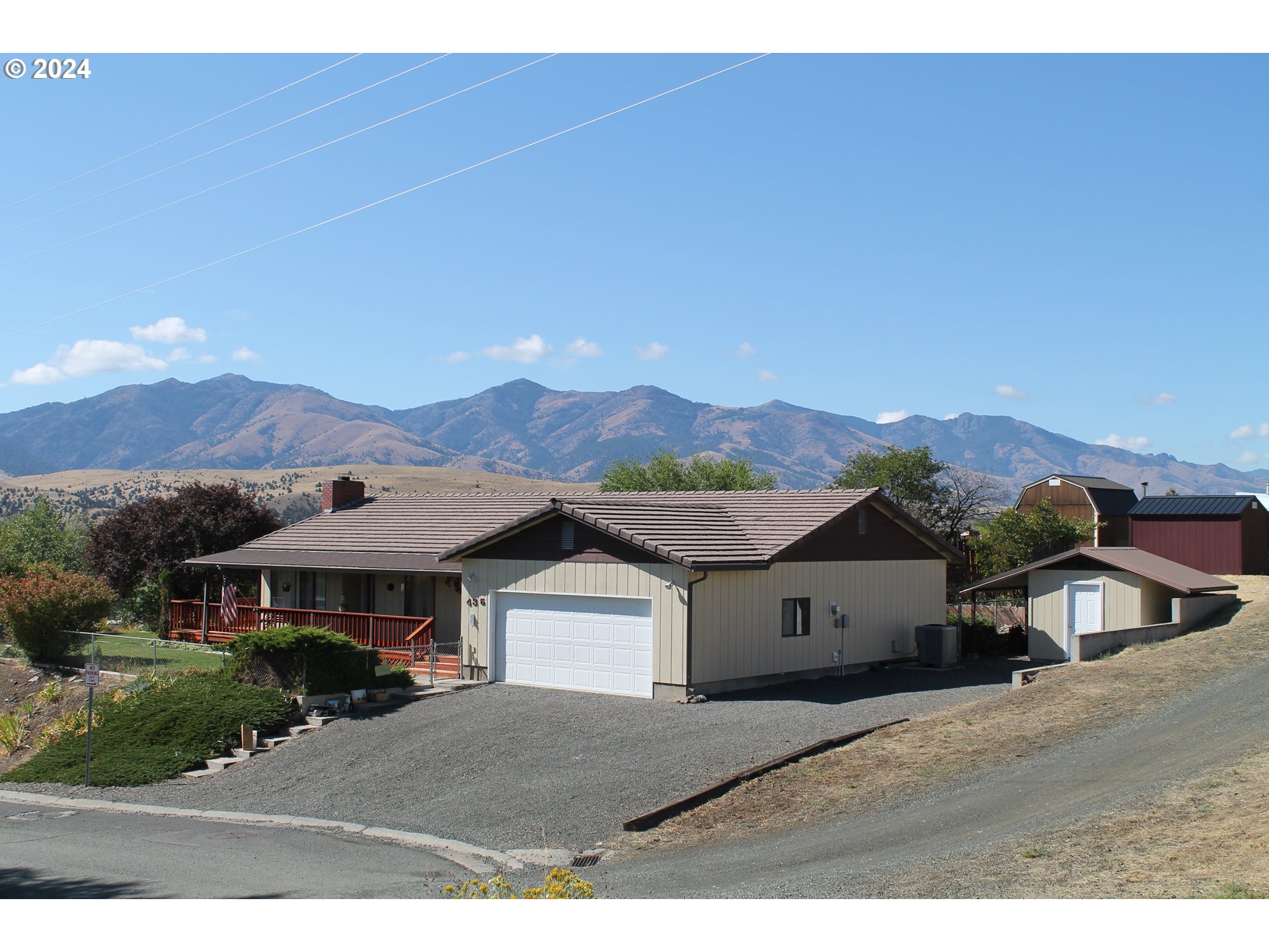 a front view of a house with a yard and mountain