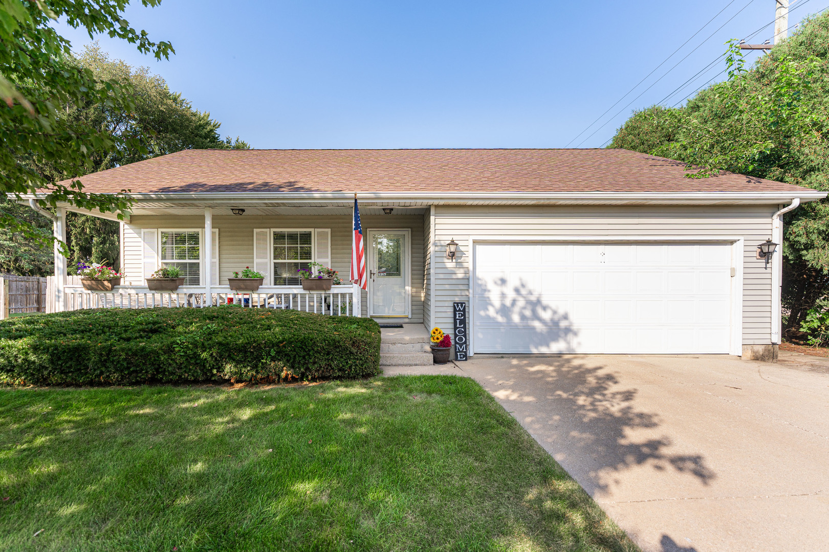 a front view of a house with a yard and potted plants