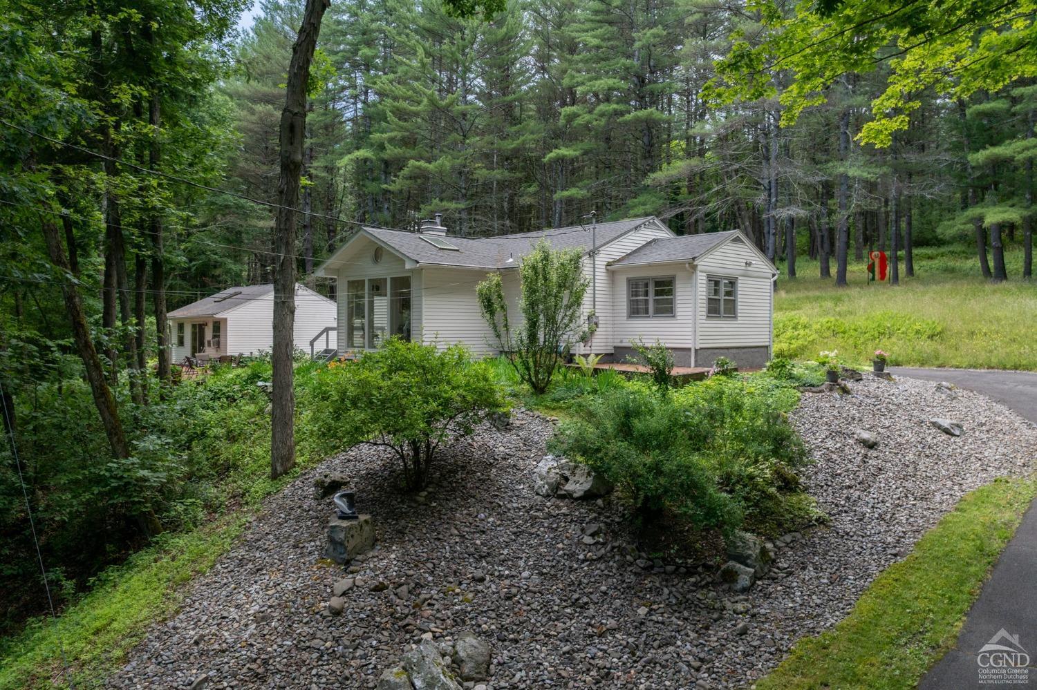 a front view of a house with a yard and trees