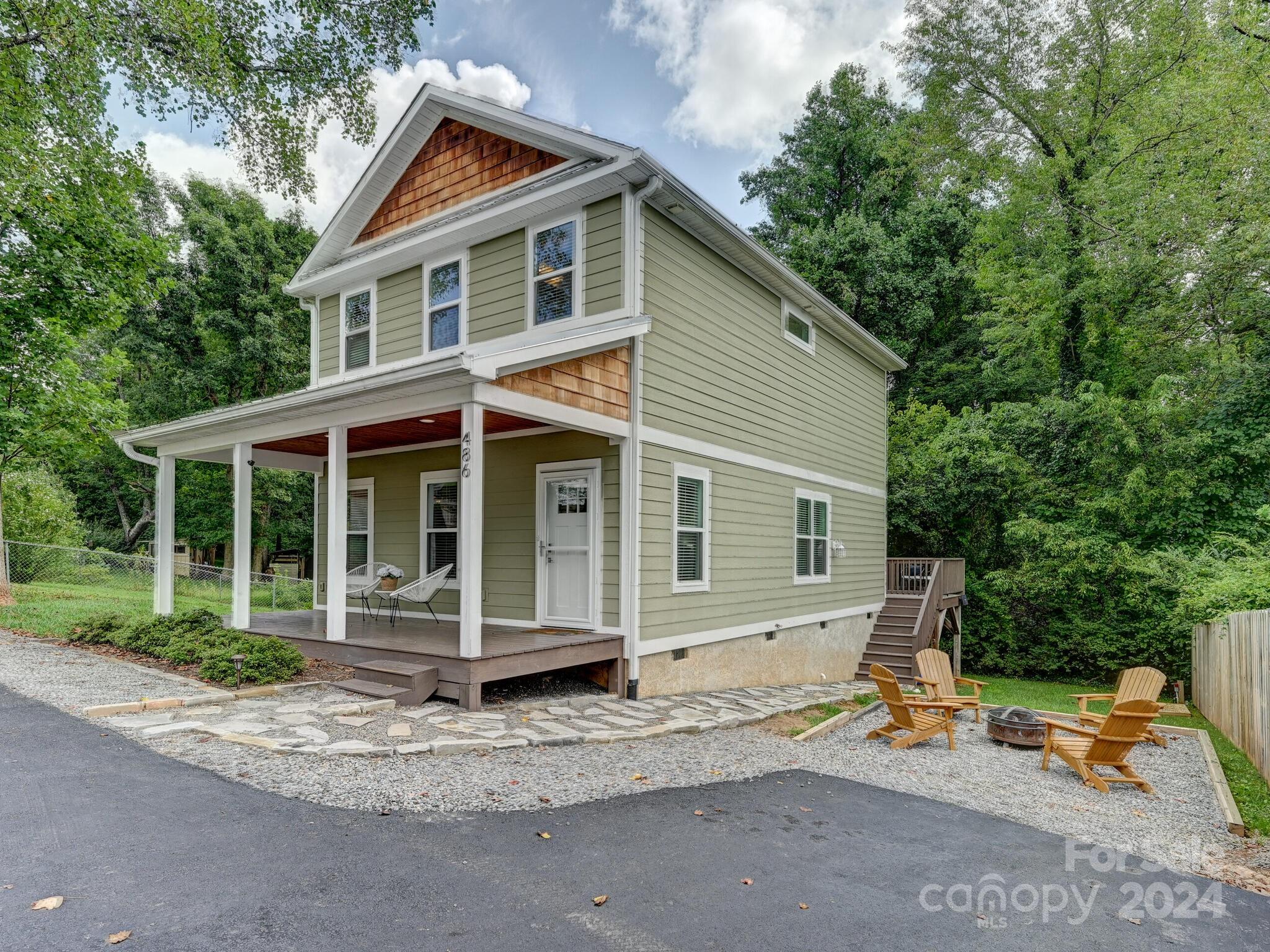 a front view of a house with a garden and trees