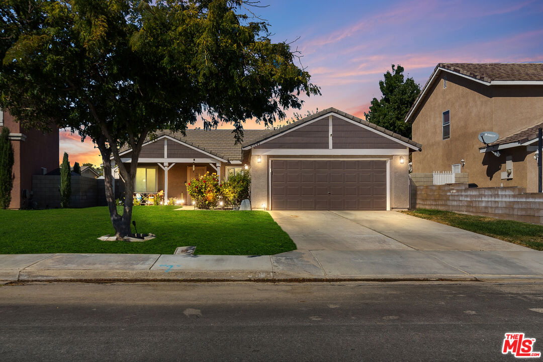 a front view of a house with garage and plants