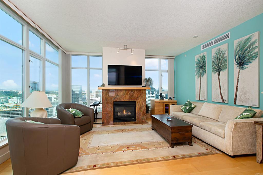 a living room with furniture a fireplace and a floor to ceiling window