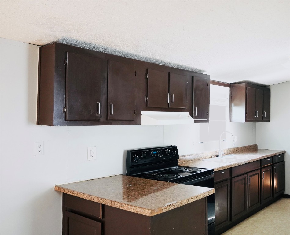 a kitchen with granite countertop a sink cabinets and stainless steel appliances