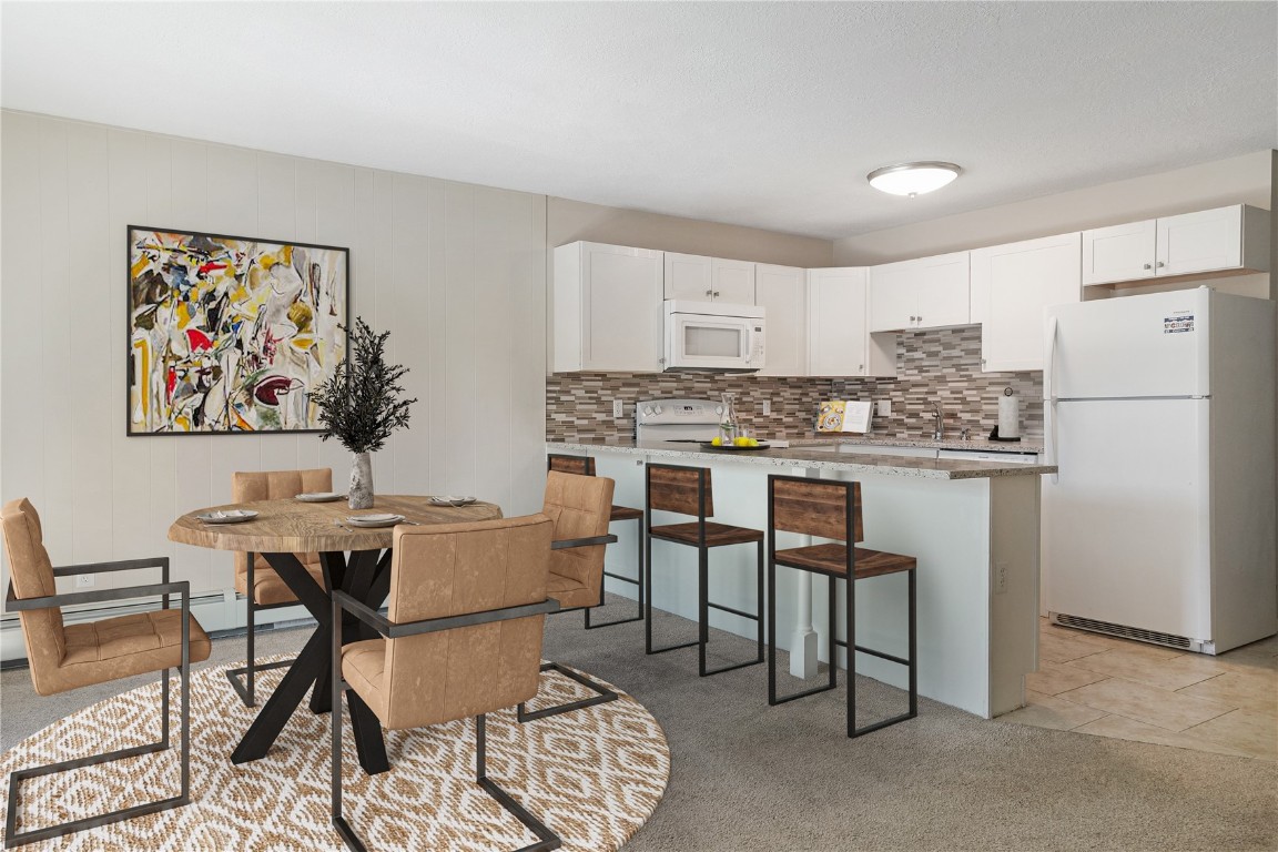 a kitchen with stainless steel appliances granite countertop a table and chairs in it