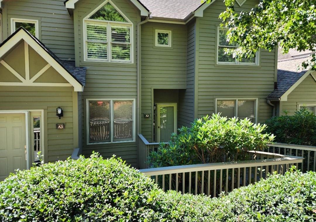 a view of a house with a small yard and flower plants