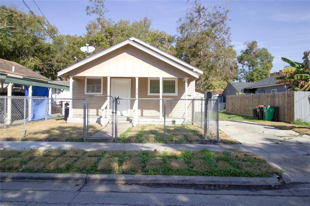 a front view of a house with a yard and potted plants