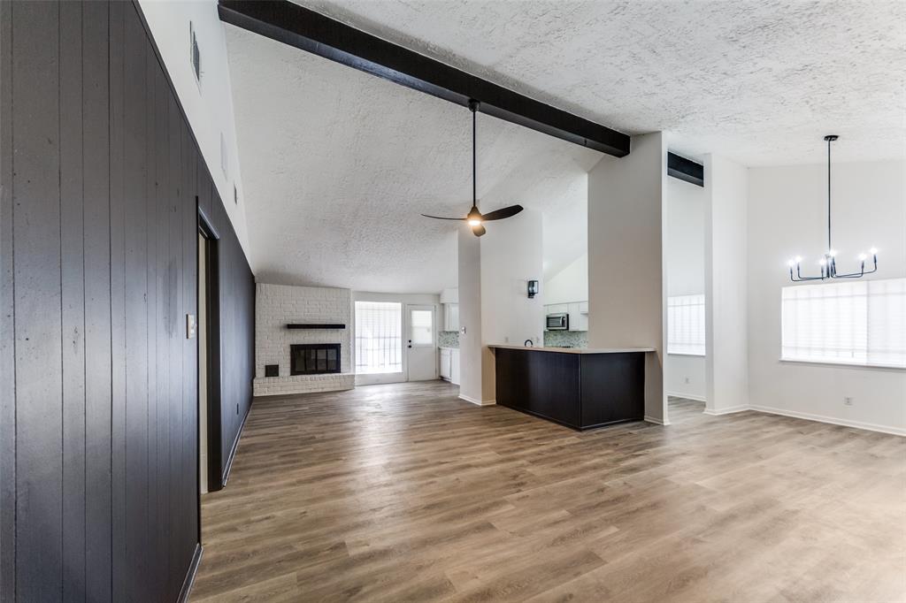 a view of an empty room with a kitchen and a window