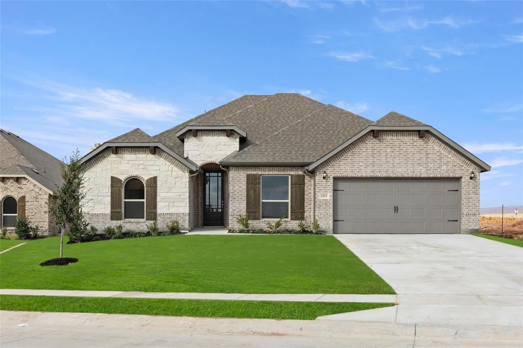 a front view of a house with a garden and yard