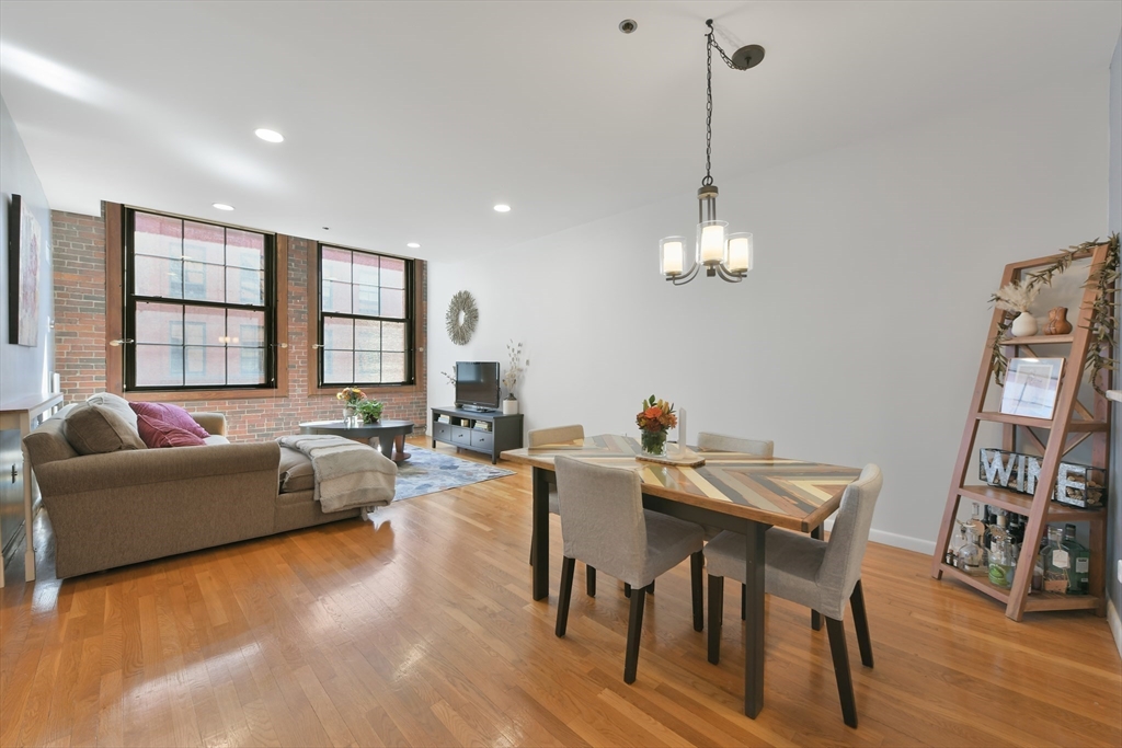 a living room with furniture a window and wooden floor