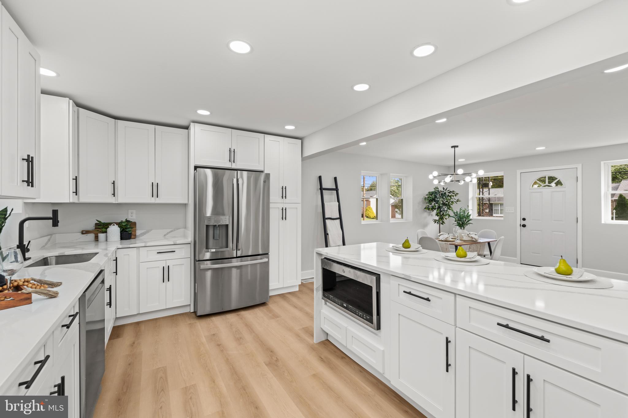 a kitchen with a sink white cabinets and stainless steel appliances