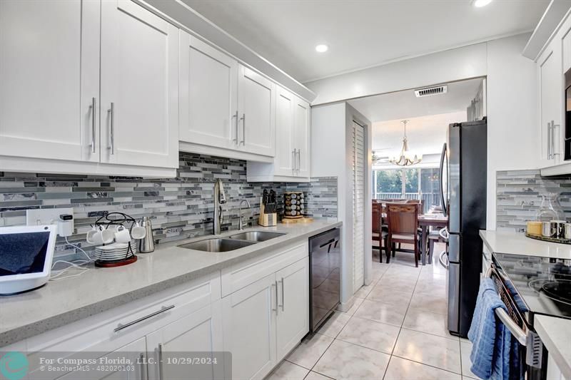 a kitchen with a sink a stove and cabinets