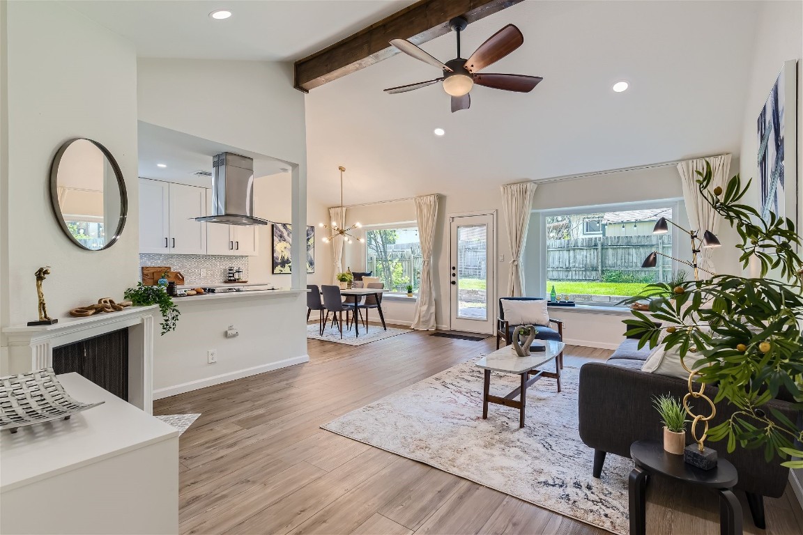 a living room with furniture a large window and wooden floor