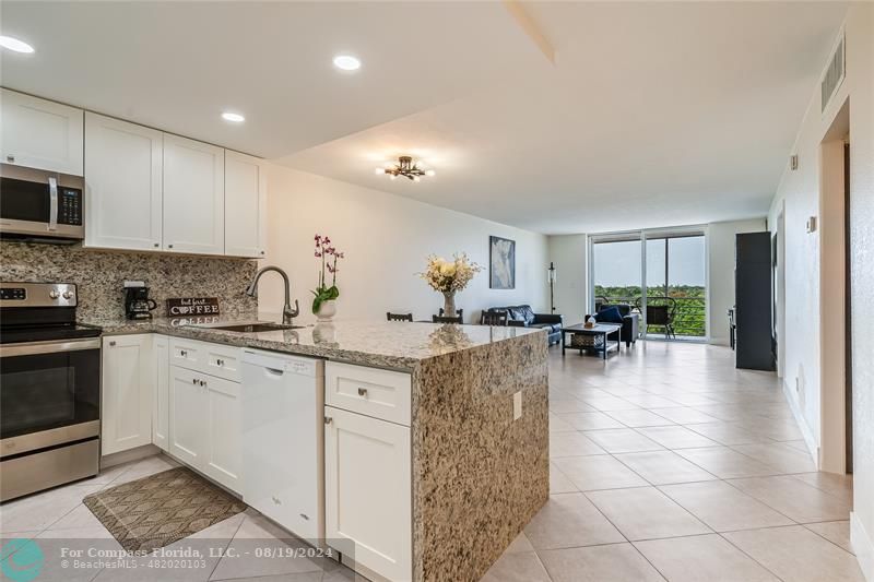 a kitchen with stainless steel appliances granite countertop a refrigerator sink and cabinets