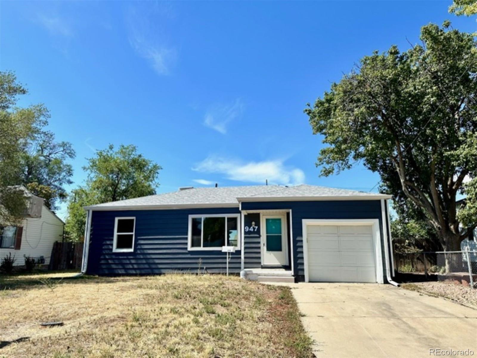 a front view of house with yard and trees in the background