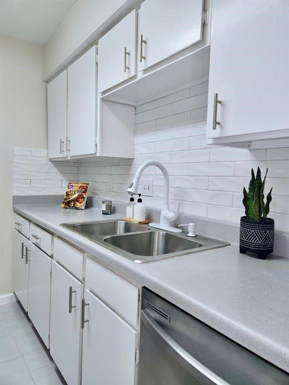 a kitchen with white cabinets a sink and dishwasher