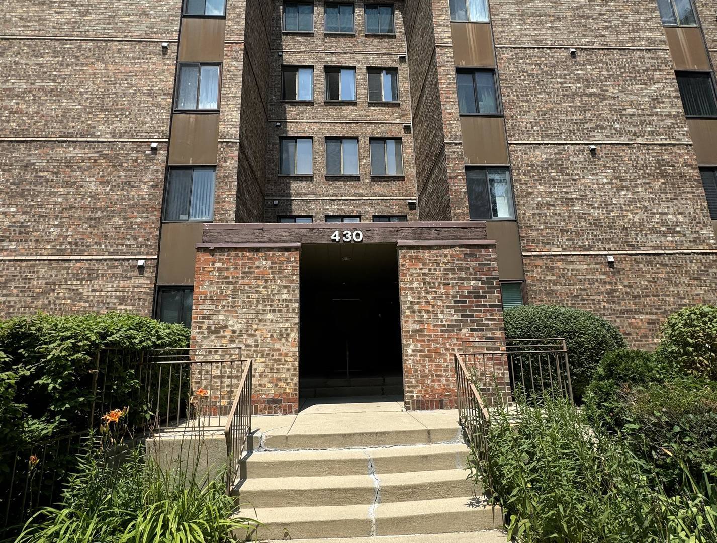 a front view of a building with a garden