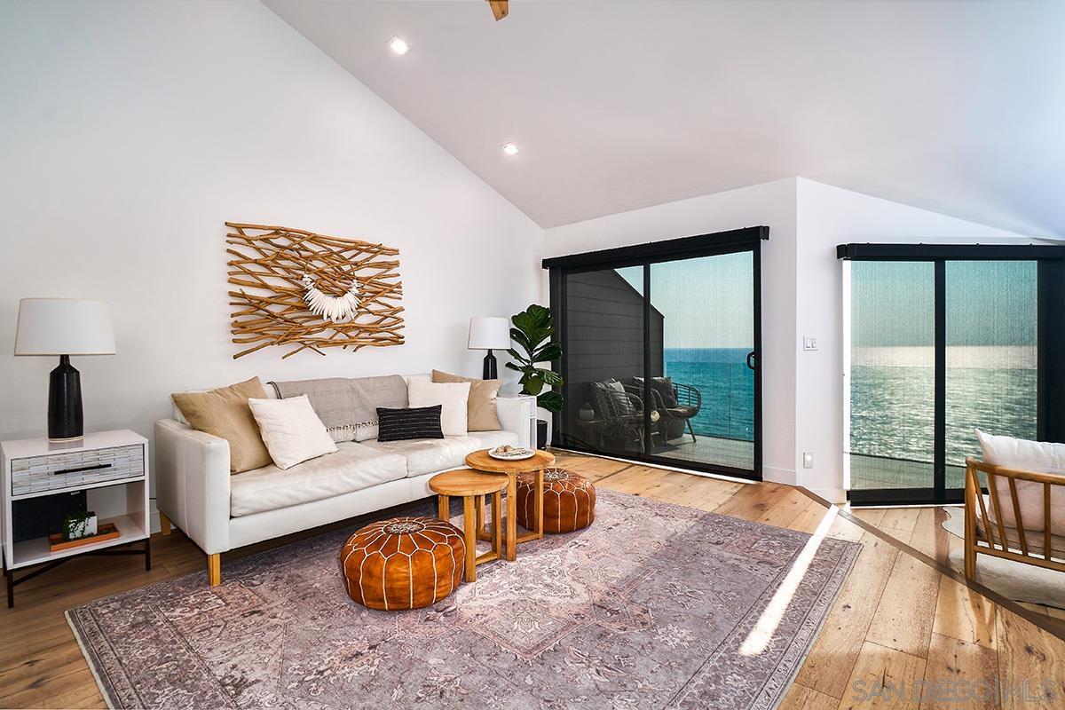 a living room with furniture a floor to ceiling window and potted plant