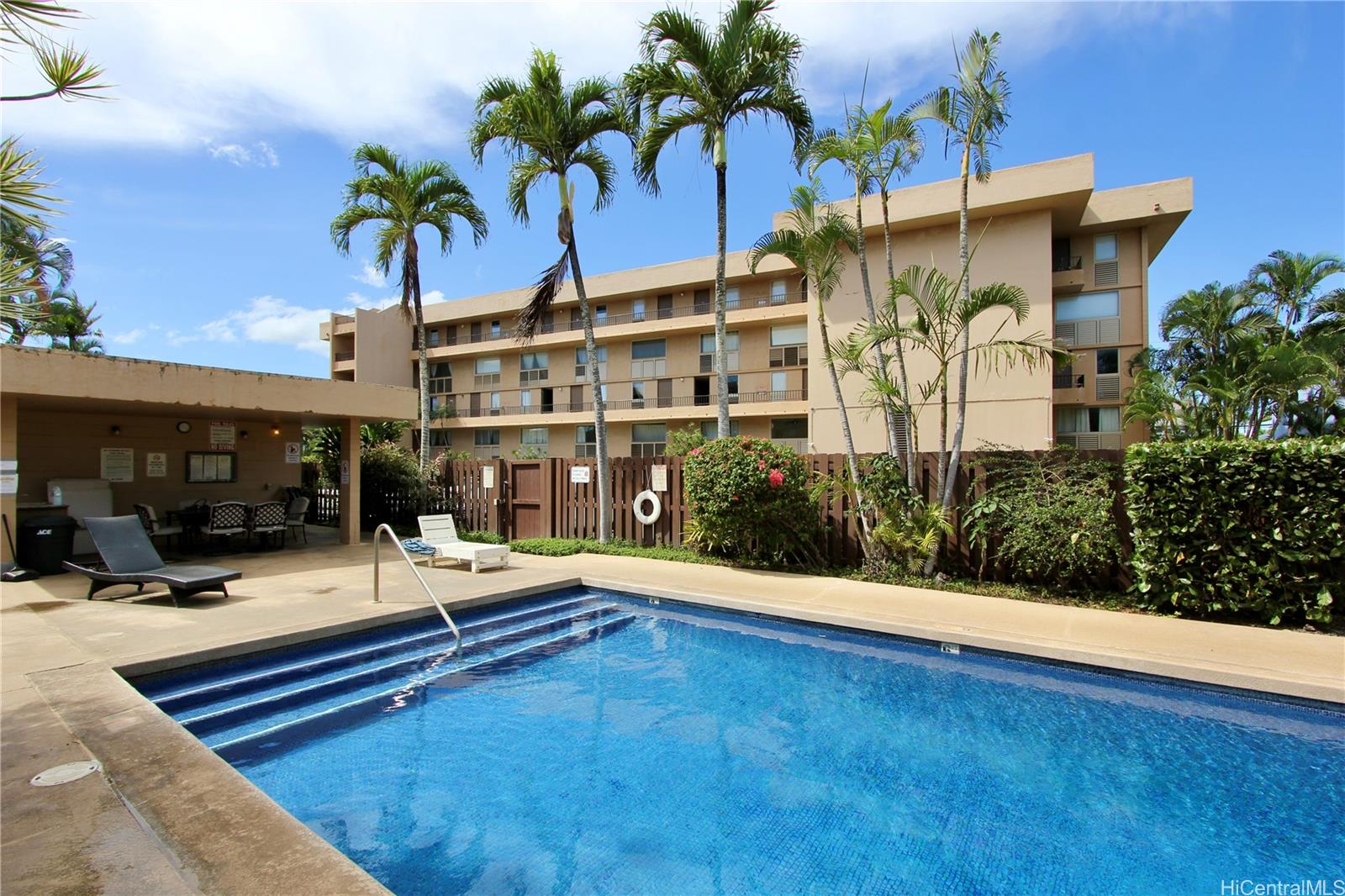 a view of swimming pool with outdoor seating and house in the background