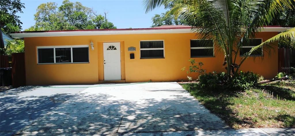 a front view of a house with plants