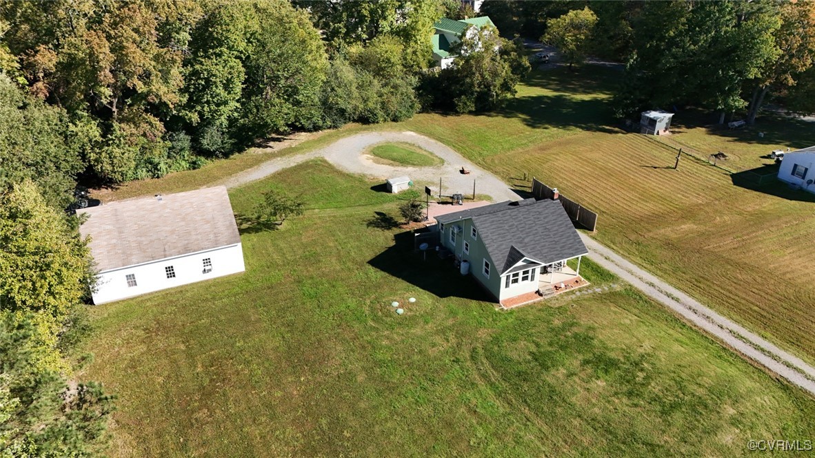 an aerial view of a house with a yard and a large tree