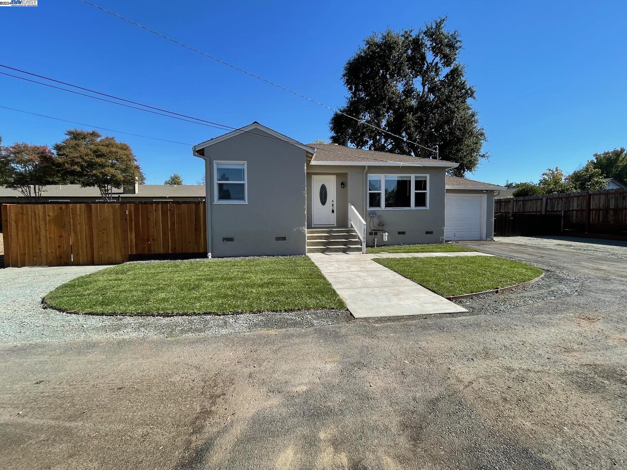 a view of a house with a yard and potted plants