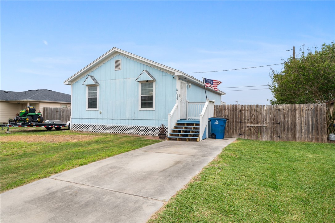 a view of a house with a yard and fence