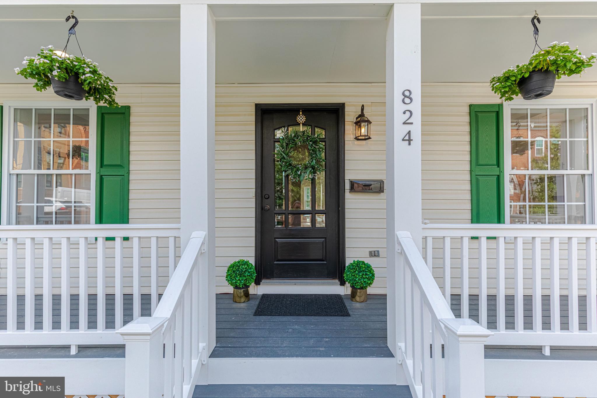 a front view of a house with potted plants