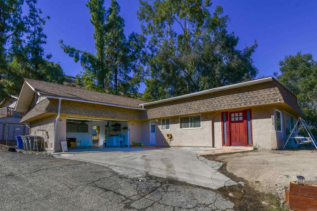 a view of a house with a garage and large tree