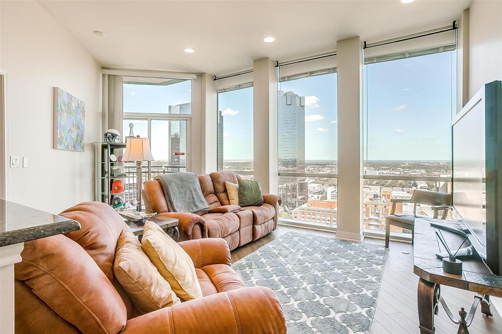 a living room with furniture and floor to ceiling windows