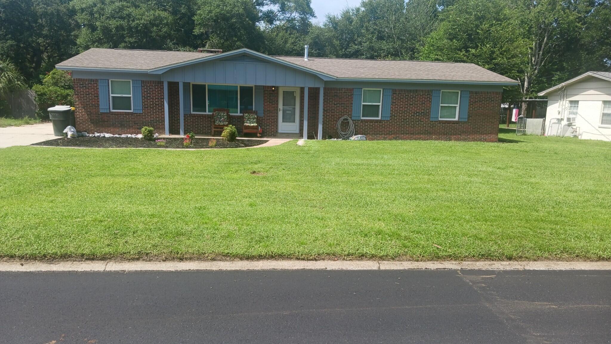 a front view of a house with a yard and trees