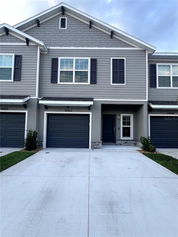 a front view of a house with yard and parking